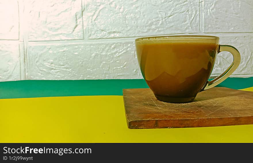 A cup of milk coffee served with hot water.