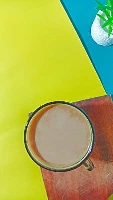 A Cup Of Hot Milk Coffee Placed On A Cutting Board With A Double-colored Background, Top View, Vertical Shot, Still Life And Flat Royalty Free Stock Images