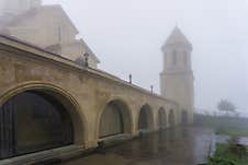 Tiled Church Courtyard, Lower Part With Rooms, Bell Tower In The Fog Royalty Free Stock Photos