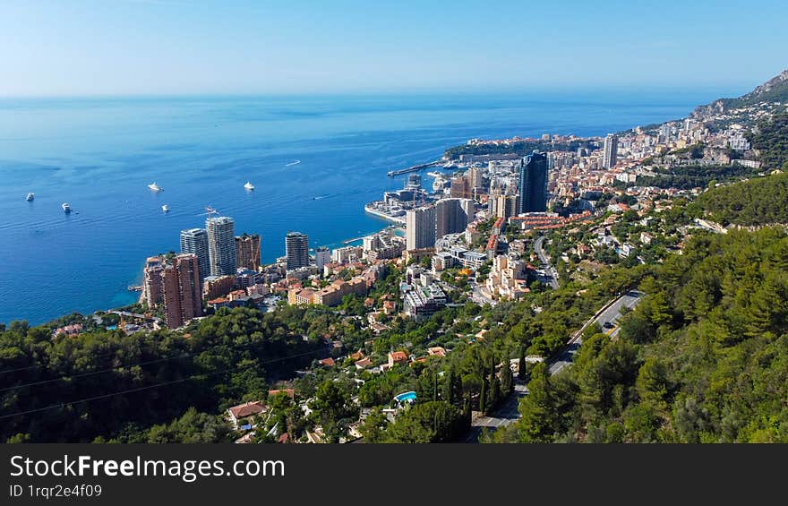 view of rich city of Montecarlo, tall buildings, narrow streets famous for formula 1 race. mountain, sea and beautiful city on a sunny day vacation and tourism in rich city with yachts and luxury cars