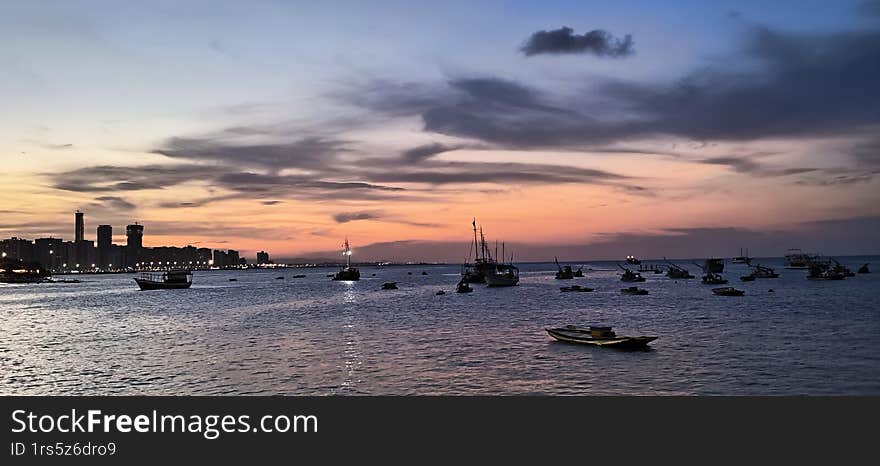 Beautiful sunset of the sea with a bay of ships, boats.