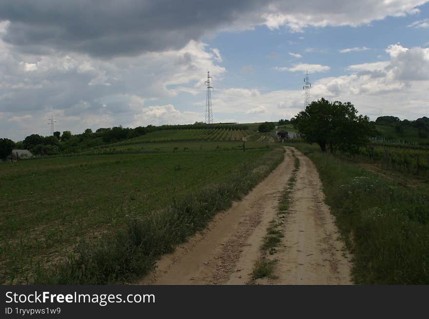 A small, dusty rural road through the fields.