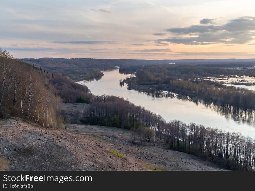 Sunset over a long river. View from a high mountain