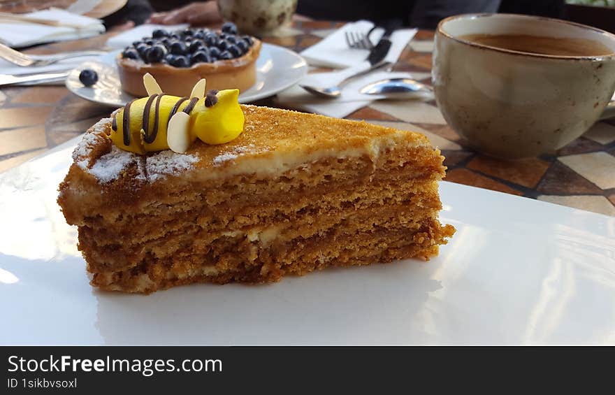 side view of a honey bee cake on a white plate