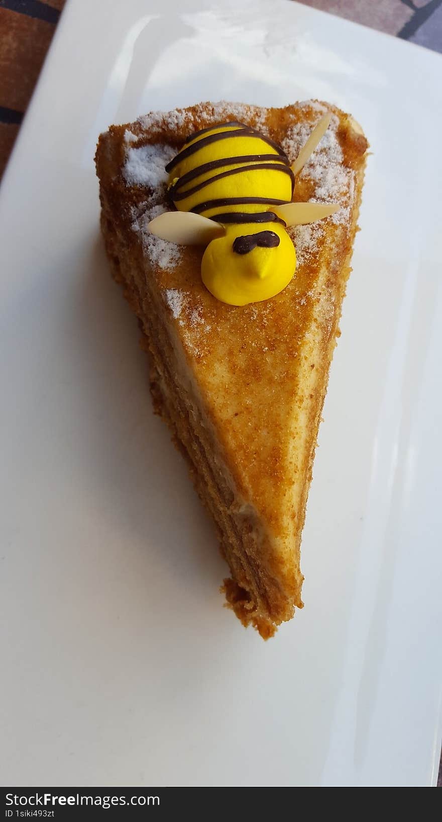 Top view of a honey bee cake on a white plate