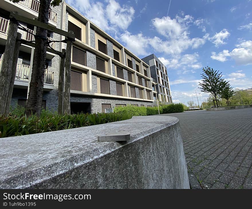 Brussels, Belgium 04-15-2025. The facade of a multi-story building in the middle of the street, in sunny weather against the blue sky. In the foreground is a stone decorative panel