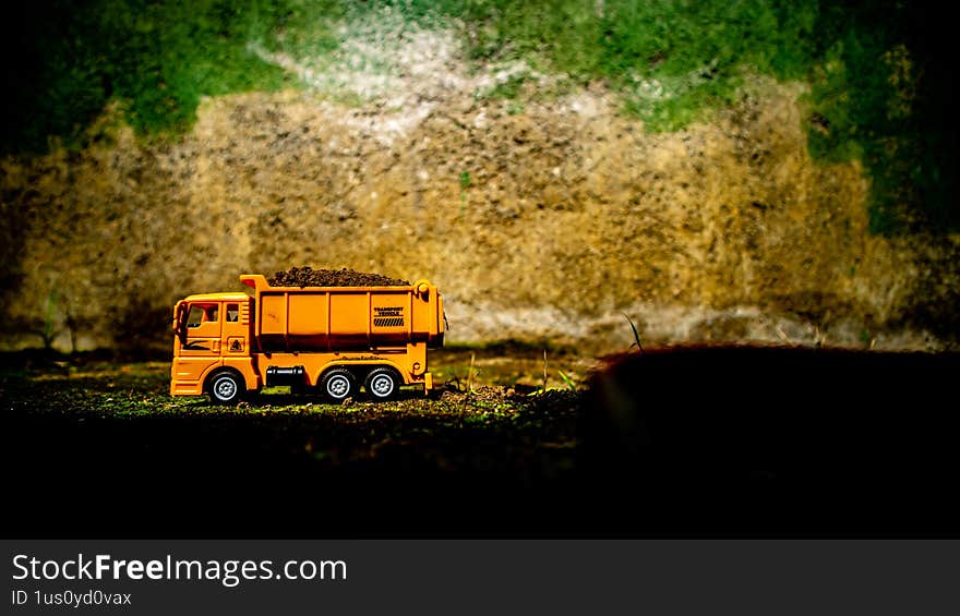 South Minahasa, Indonesia - January 3, 2023: a yellow bulldozer toy is leveling the ground