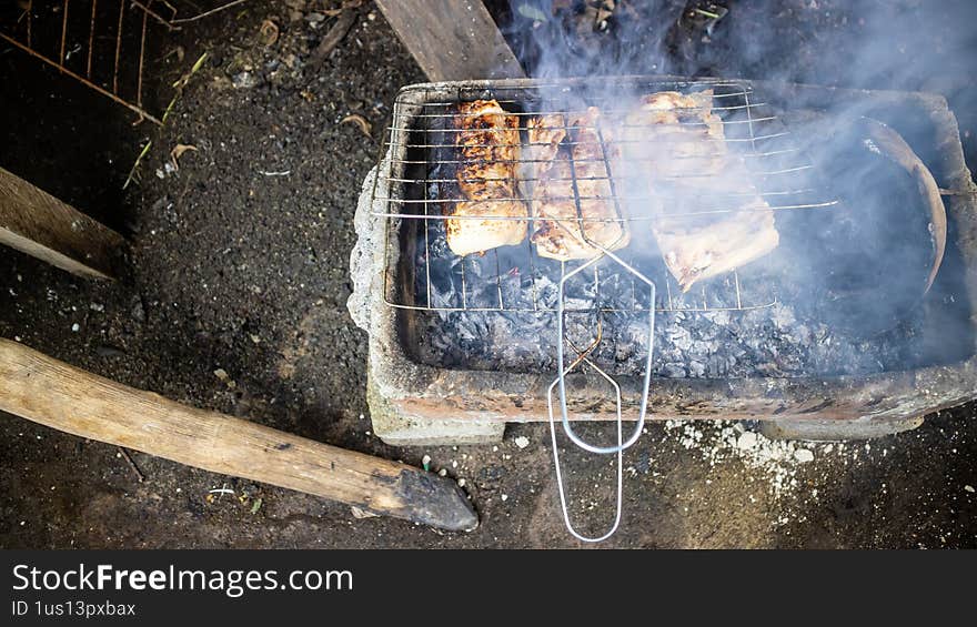Pork being grilled on a traditional grill