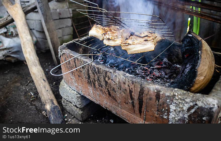 Pork being grilled on a traditional grill