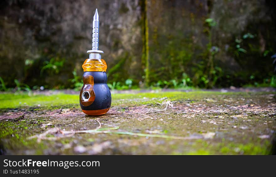 a screwdriver on the moss-covered floor. a screwdriver on the moss-covered floor