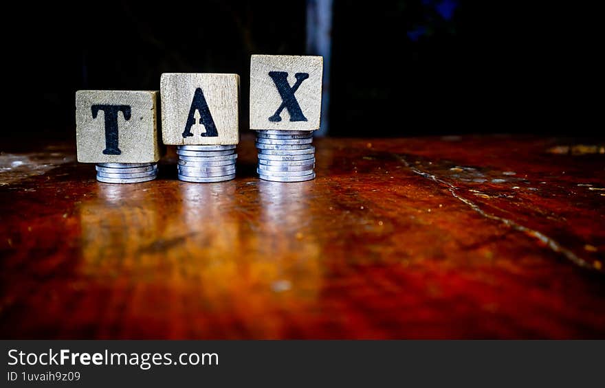 coins and blocks with tax inscription as background