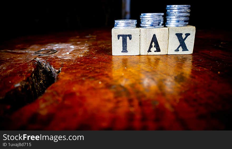 coins and blocks with tax inscription as background