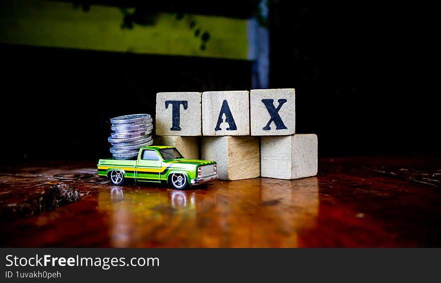 tax writing on wood with coins on it and a toy car in the foreground