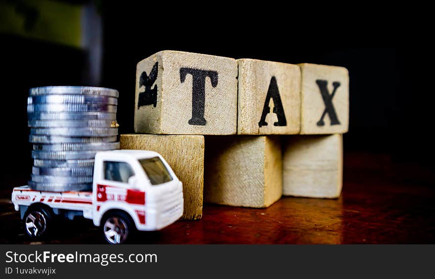 tax writing on wood with coins on it and a toy car in the foreground