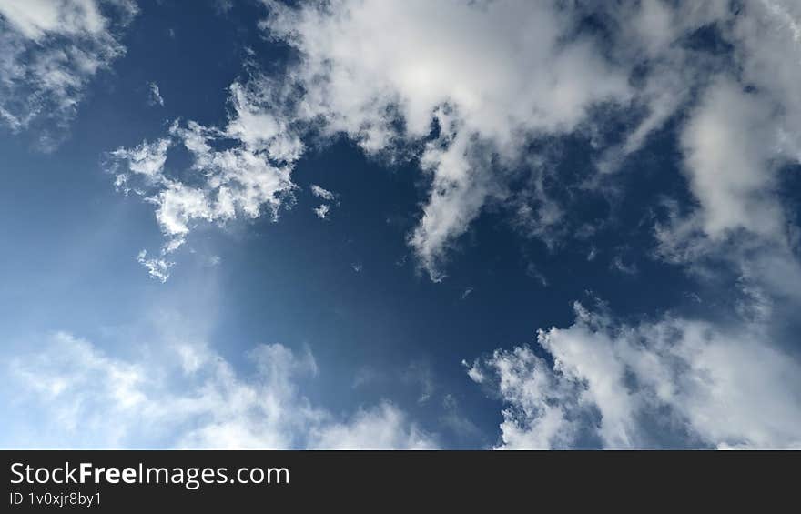 Peaceful view of a vibrant blue sky with fluffy white clouds floating gently, evoking a sense of calm, freedom, and serene natural beauty.