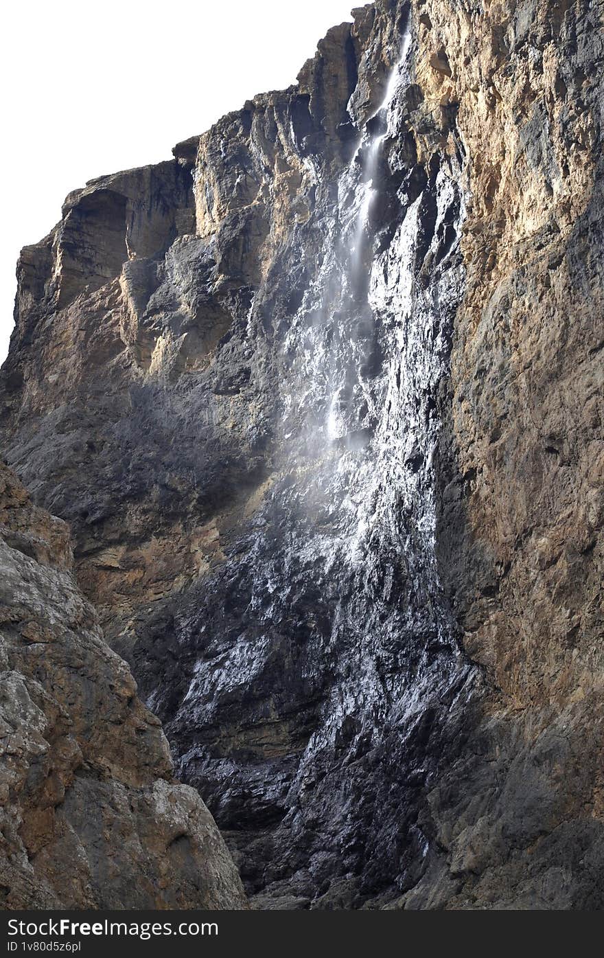 A waterfall flowing through a narrow crevice between rocks in Shahdag in the Caucasus Mountains