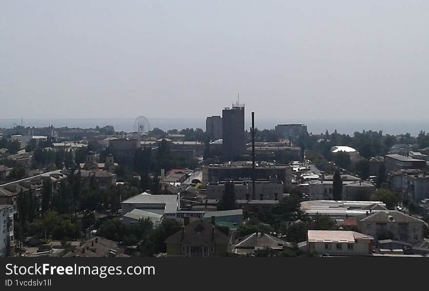A scenic panoramic view of the historic city of Berdyansk, captured from a high vantage point. The image showcases the charming architecture of the old town, with its blend of 19th-century buildings and modern structures, set against the backdrop of the Sea of Azov. This picturesque scene reflects the rich cultural heritage and coastal beauty of Berdyansk, a prominent port city in southeastern Ukraine.