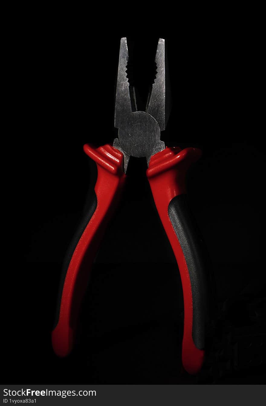 pliers, a tool, stands on a black background
