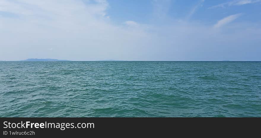 ocean wave seascape in front of blue sky