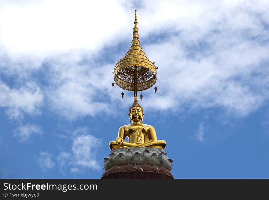 Gold Buddha statue in front of sky