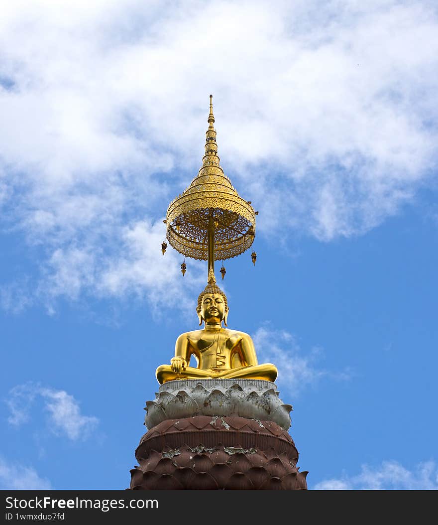 golden buddha statue on lotus statue in front of sky