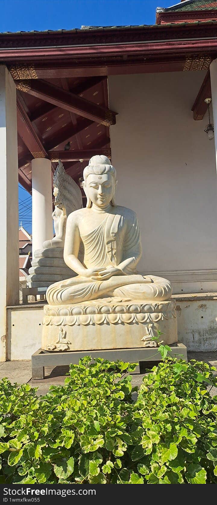 white Sculpture of a Buddha on the facade of a building