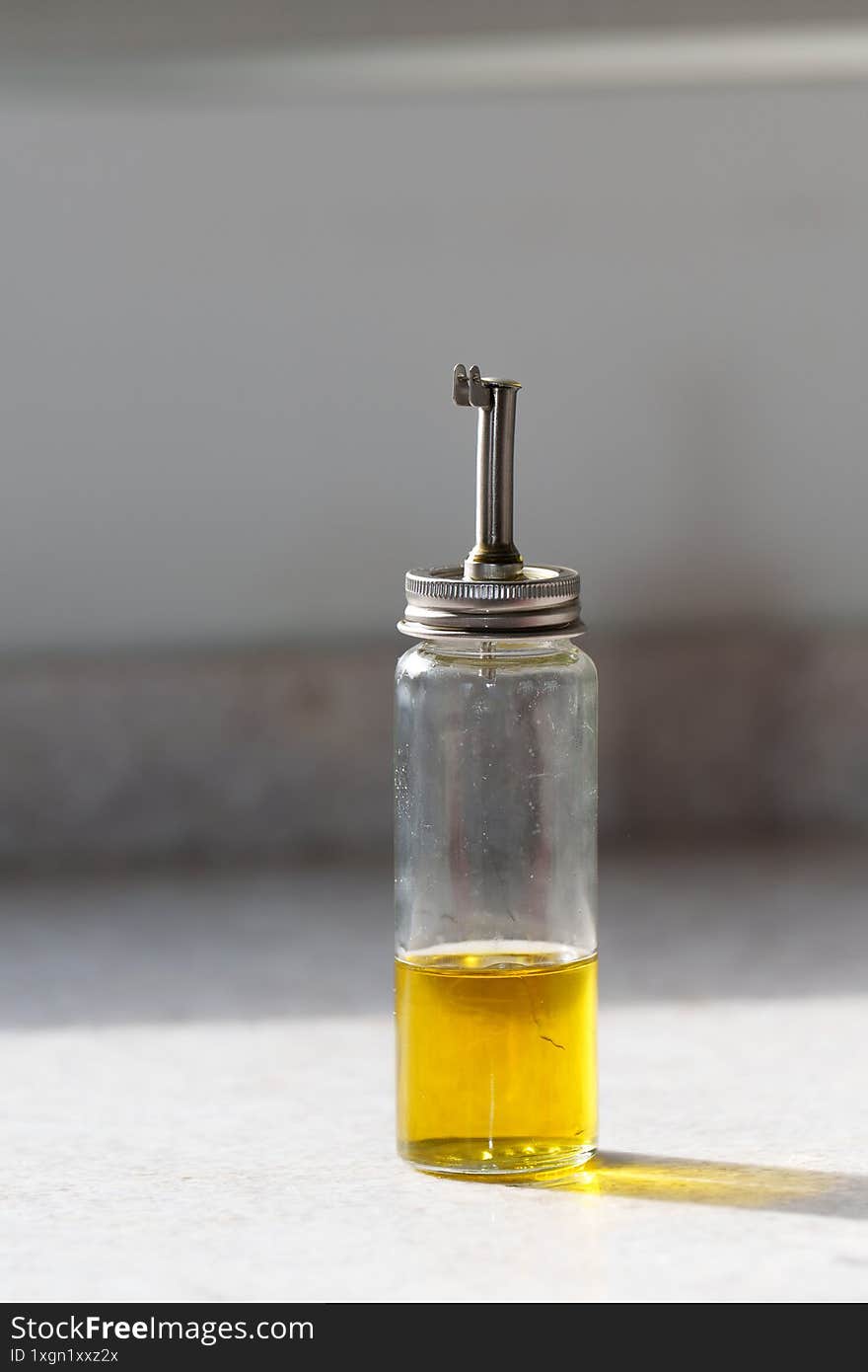 Glass olive oil dispenser on kitchen countertop