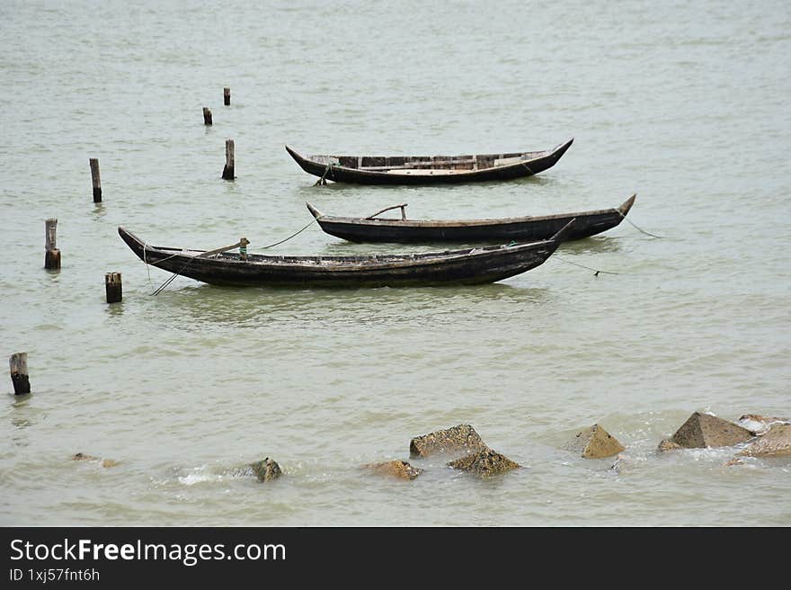 Three Traditional Boats Moored in Calm River Water