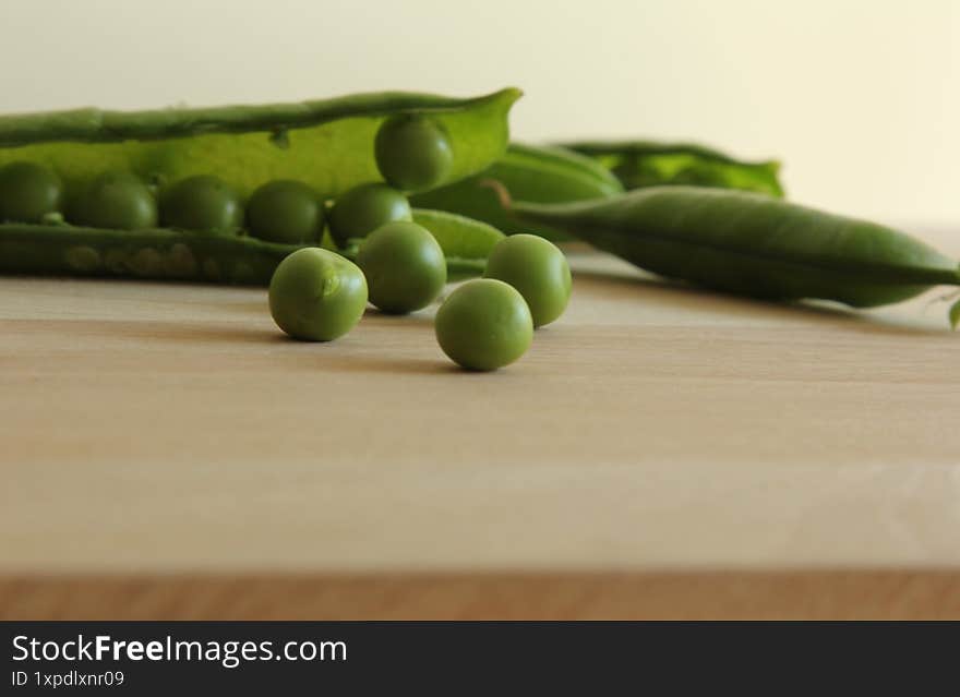 Peas on a wooden board.