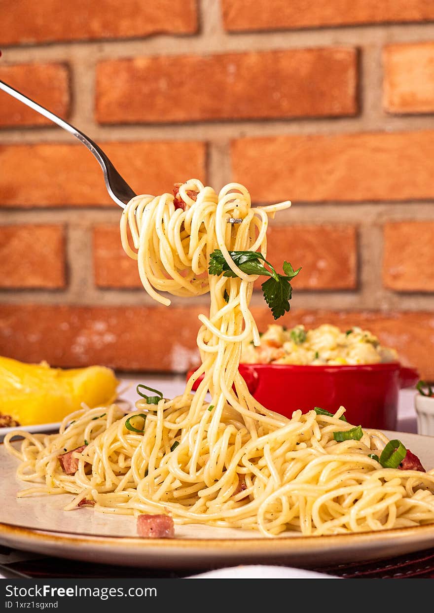 Fork picking up pasta on the table