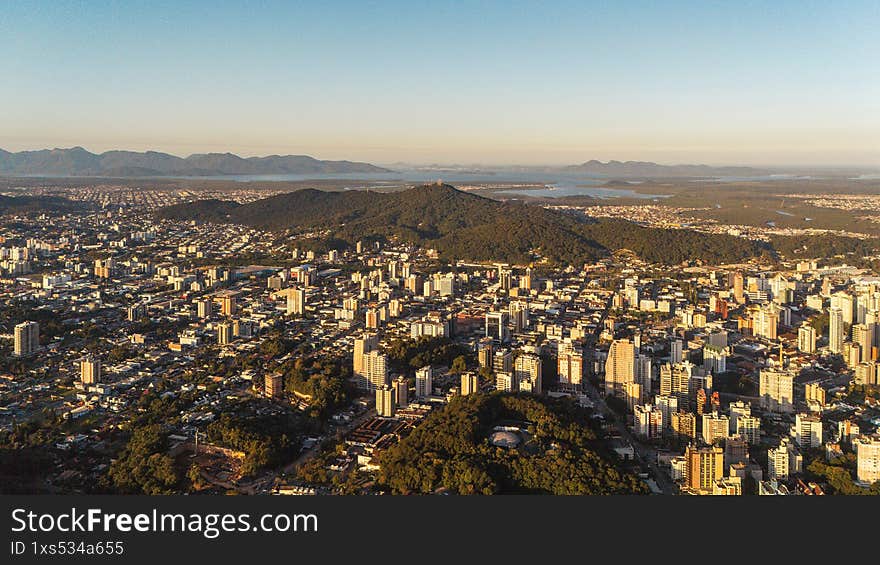 Panoramic Drone View of a Mid-Sized Brazilian City with Buildings and Green Areas Under a Clear Sky