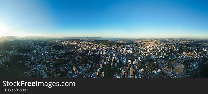 Panoramic Drone View of a Mid-Sized Brazilian City with Buildings and Green Areas Under a Clear Sky
