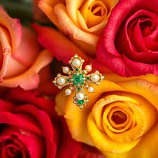 Pearl And Emerald Cross Ring On Roses Background AI Generated. Stock Images