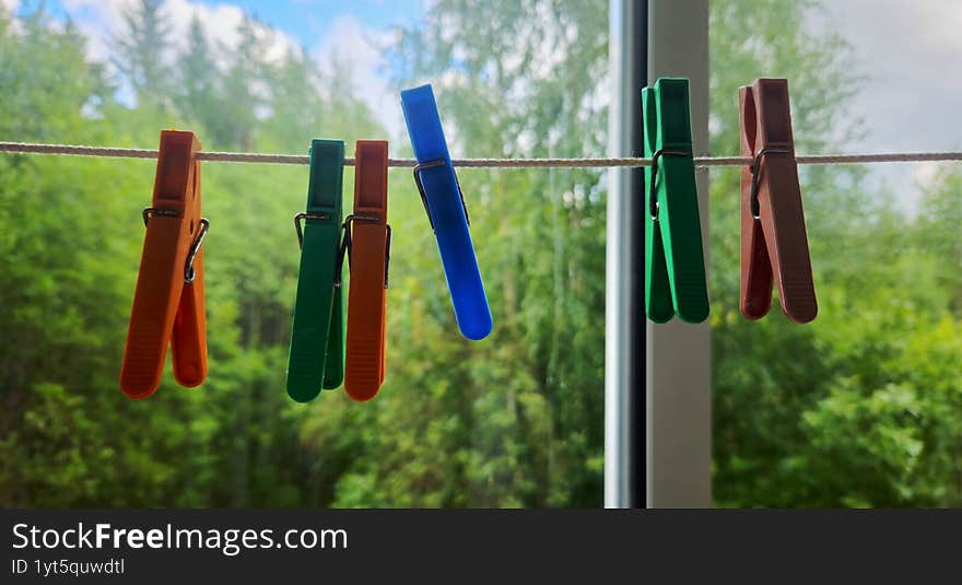 Colorful plastic clothespins on a laundry rope
