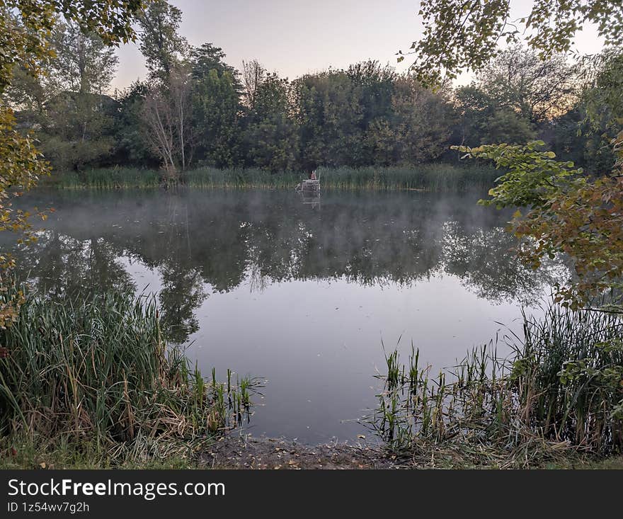 Early autumn morning with fog on the field and on the river