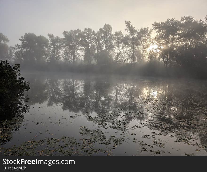 Early autumn morning with fog on the field and on the river