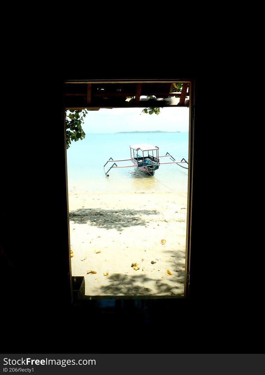 traditional wooden boat on the beach from inside the house