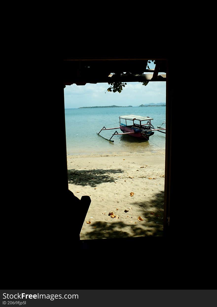 traditional wooden boat on the beach from inside the house