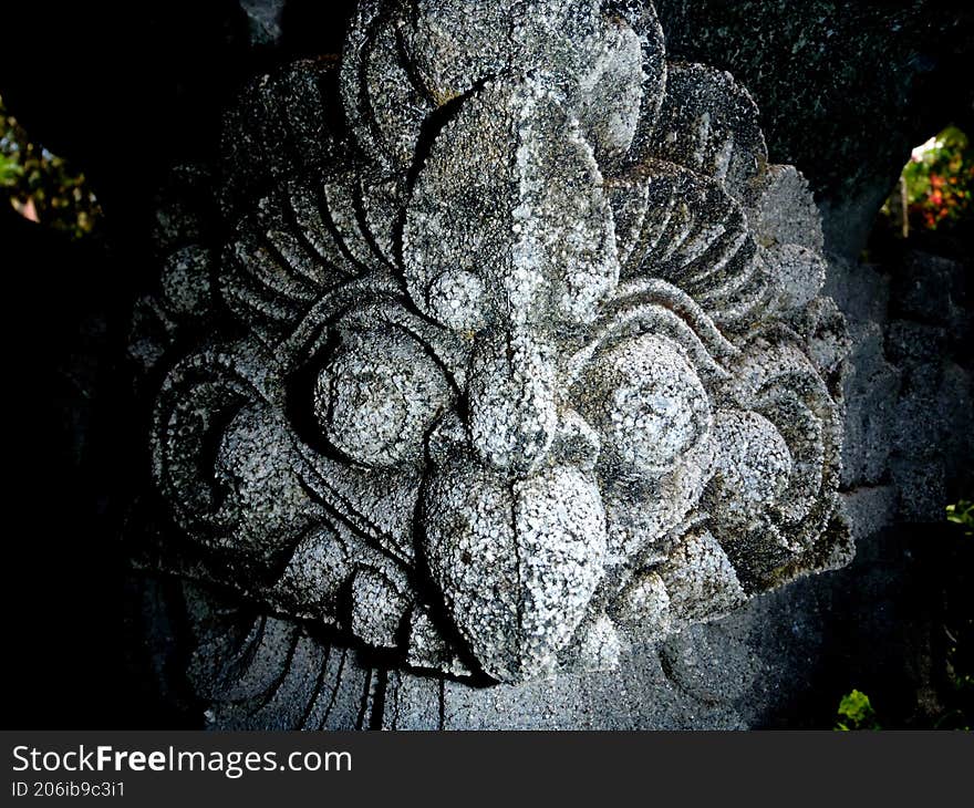 a stone statue which is similar to a head of bird