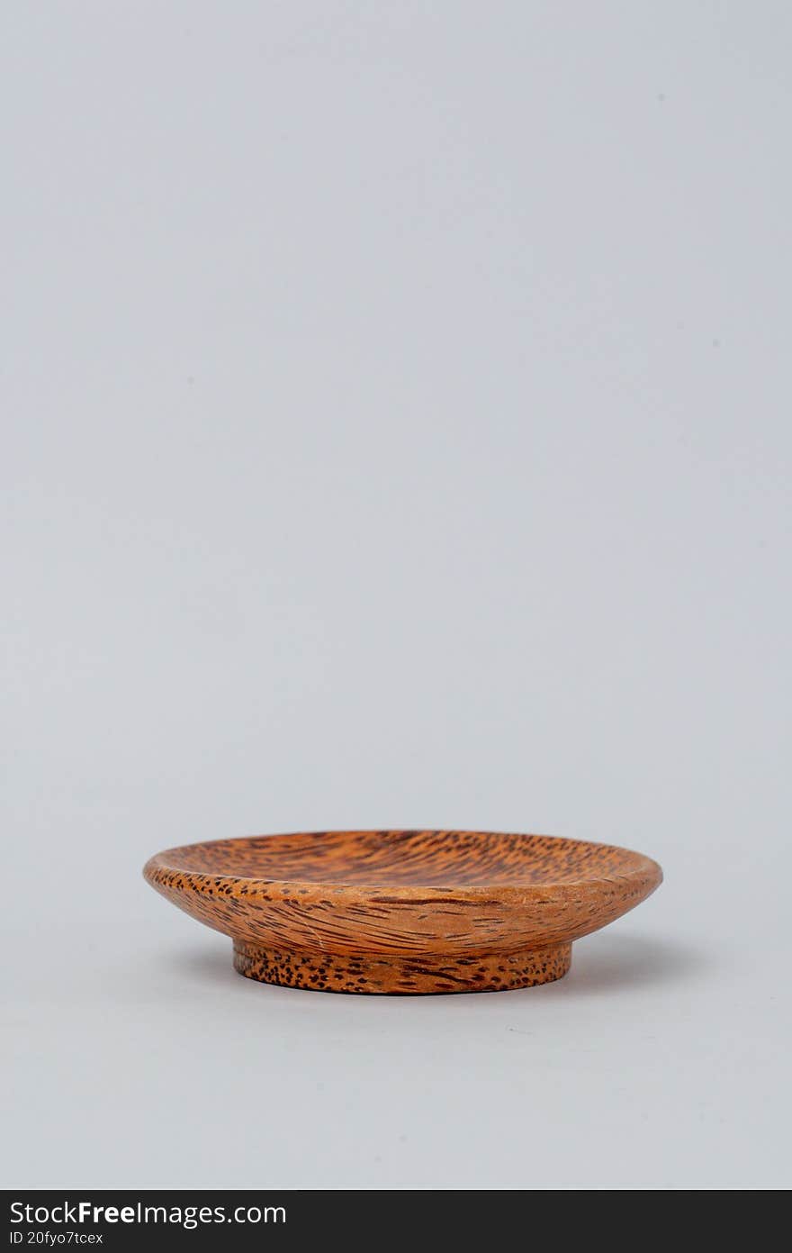 Side view small textured wooden plate on white