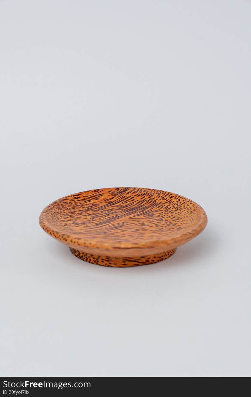 Side view small textured wooden plate on white