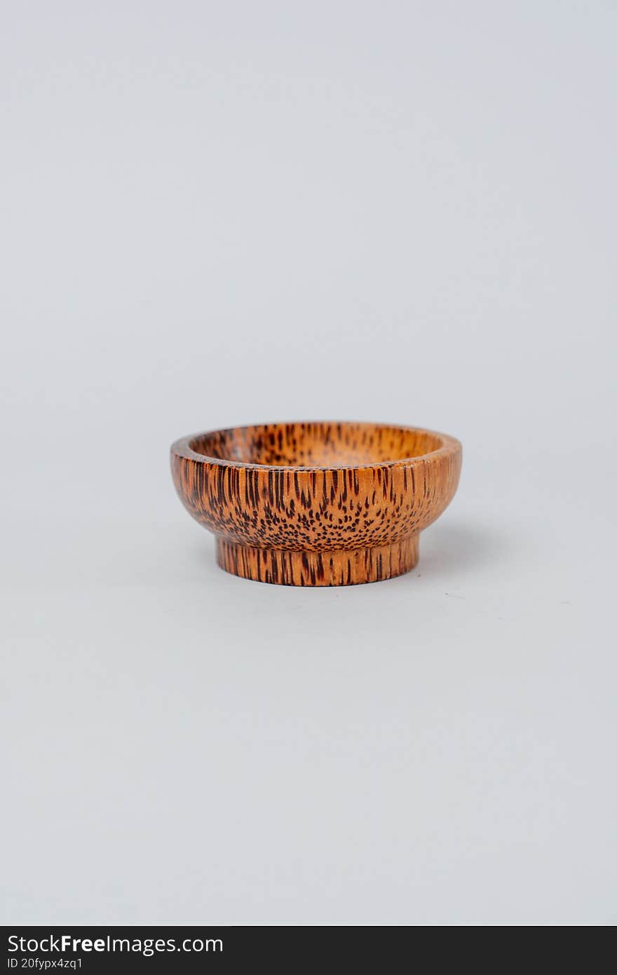 Side view small wooden textured bowl on white