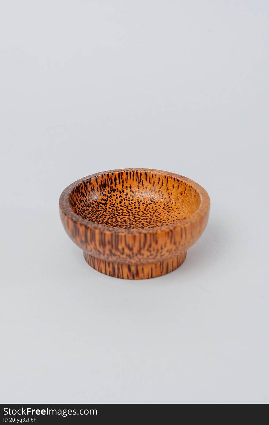 Side view small textured wooden bowl on white