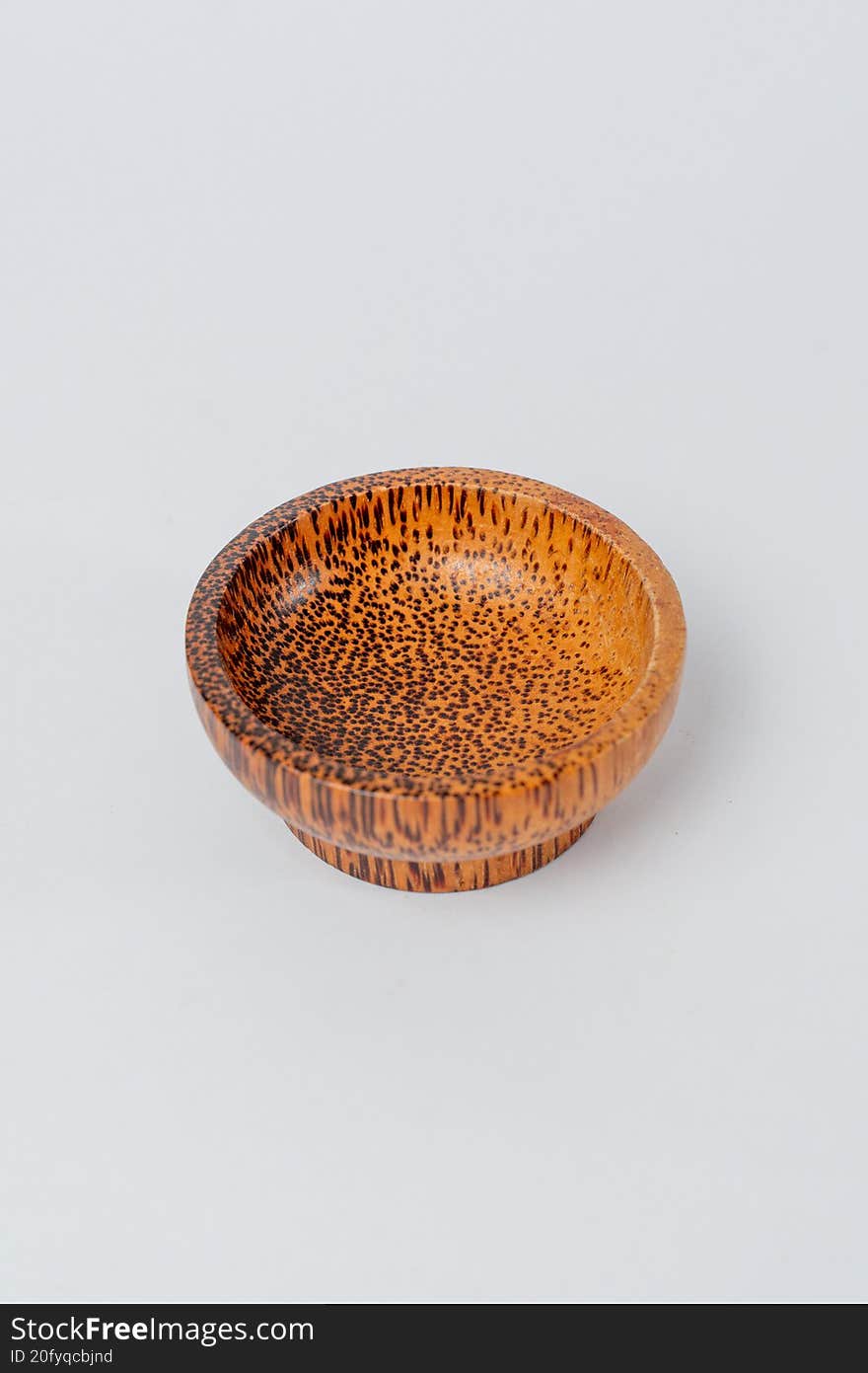 Top view small textured wooden bowl on white