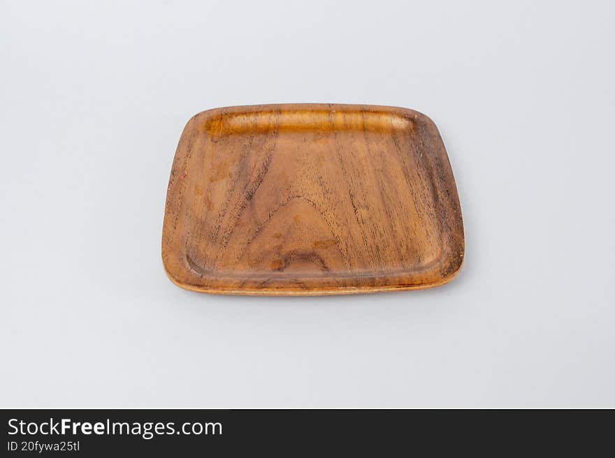 Empty wooden square plate on white