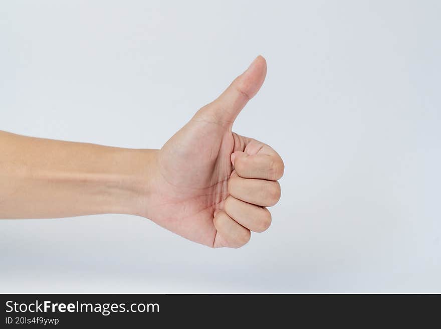 Hand showing thumbs up gesture on white