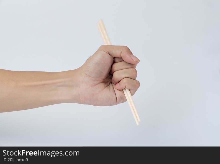 Hand holding chopsticks on white background