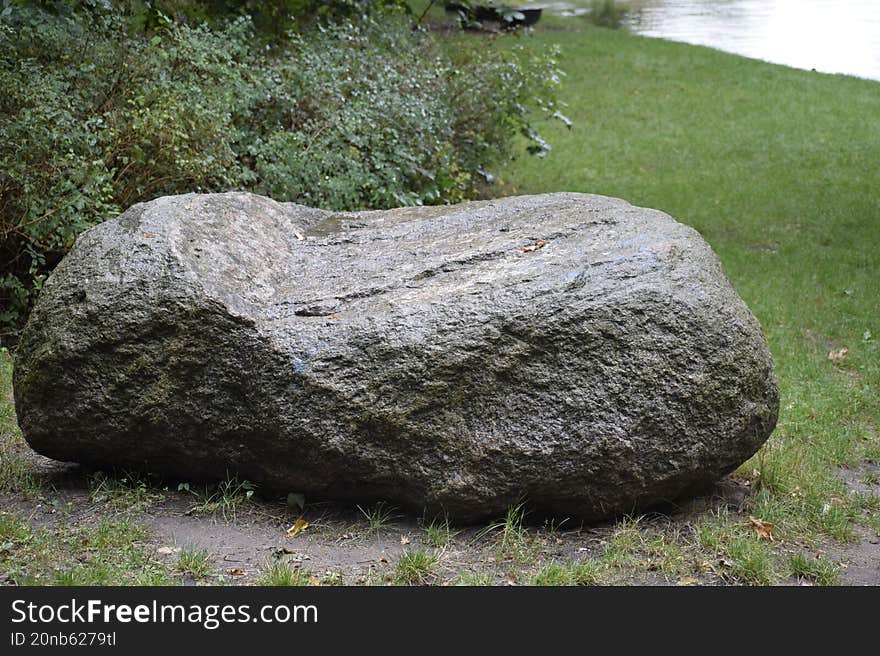 Large stone in the grass under the hill
