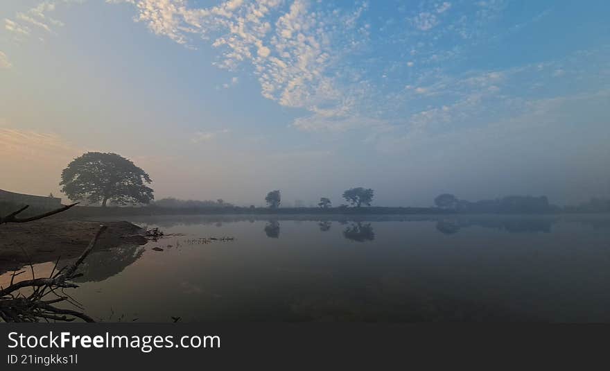 mist covering over a lake s horizon with reflection in the water