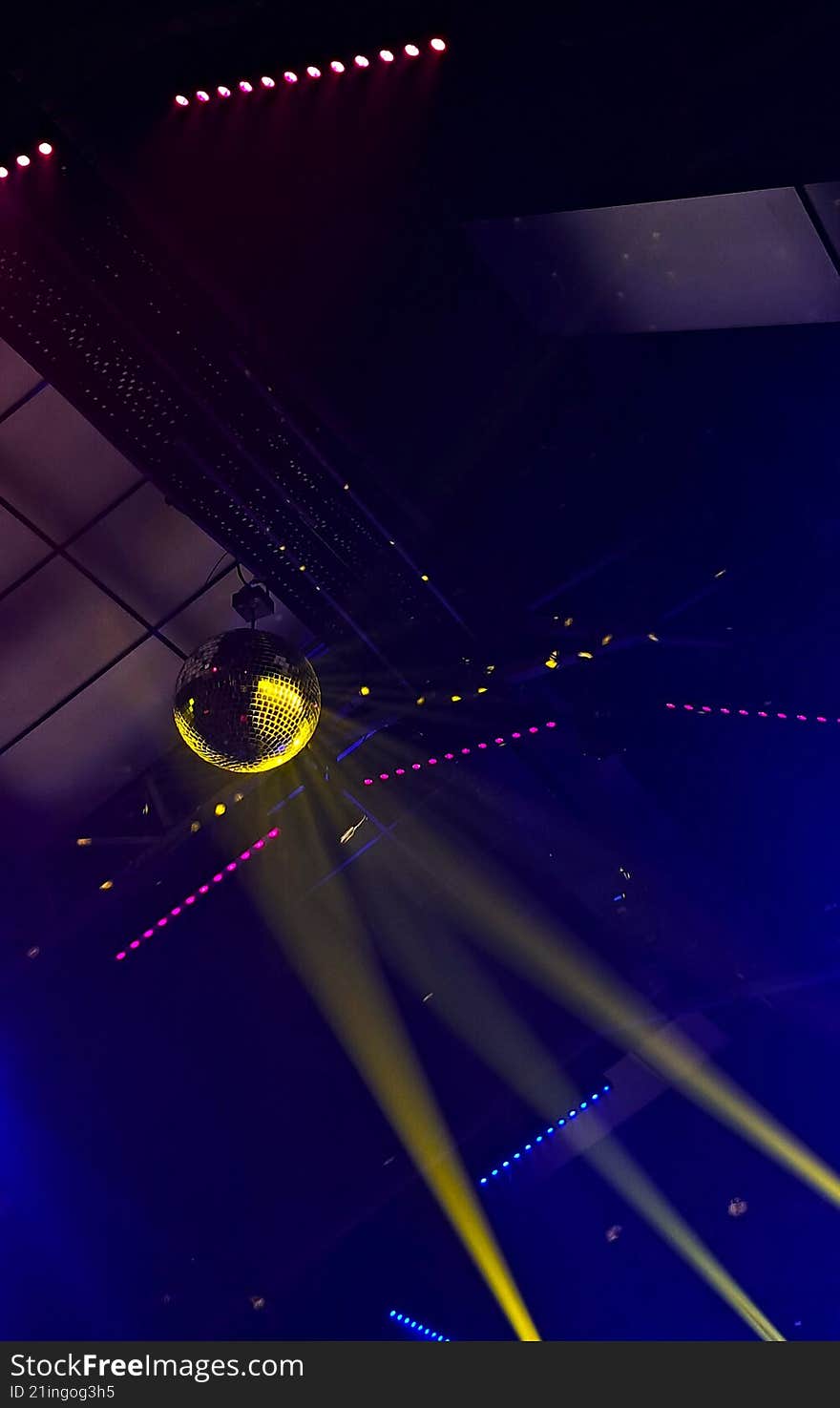 a club scene where spotlight is shining off a disco ball as main attraction